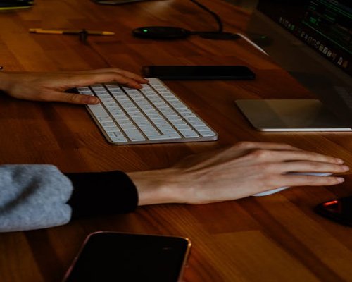 Close up of a person adjusting their sitting posture at a bright wooden office desk